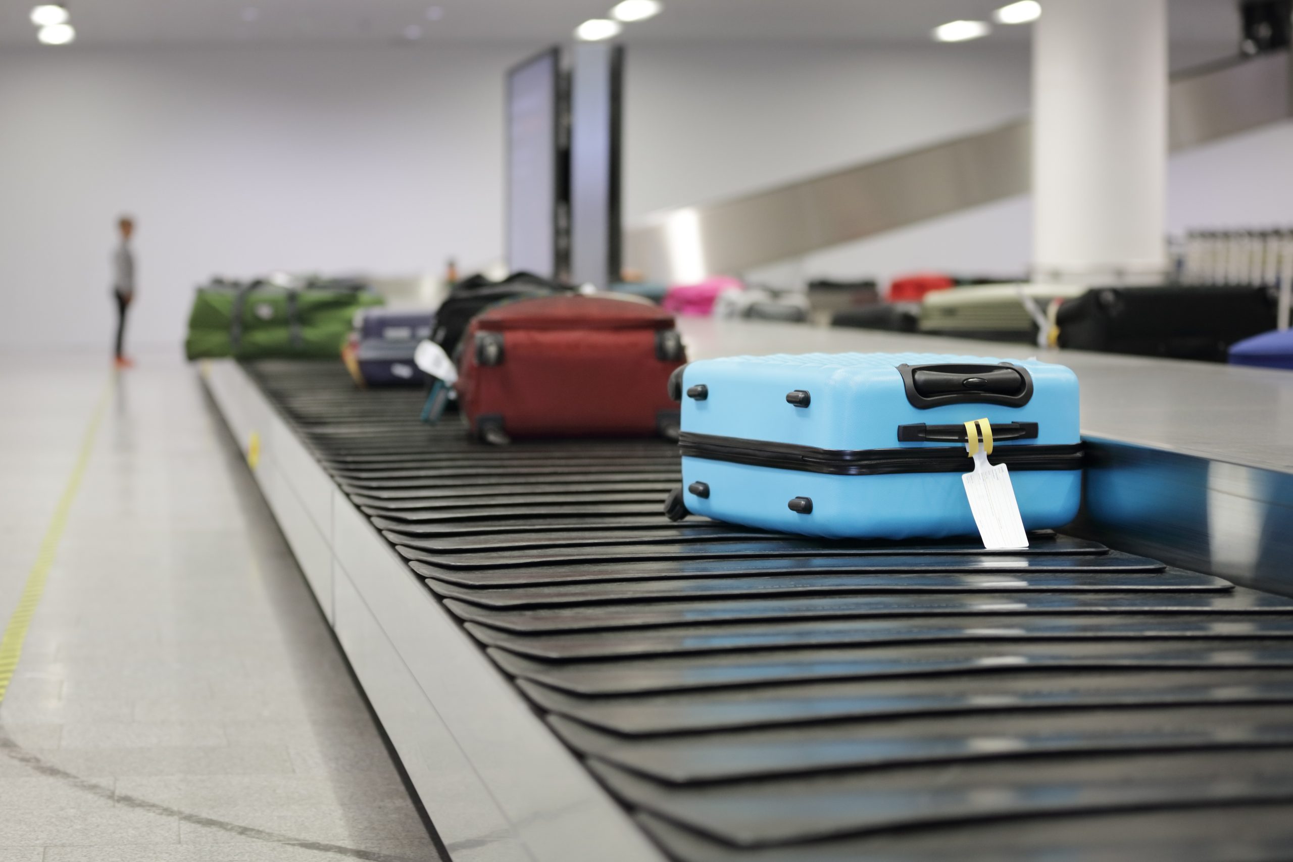 Luggage moving along the conveyor belt at the airport terminal.